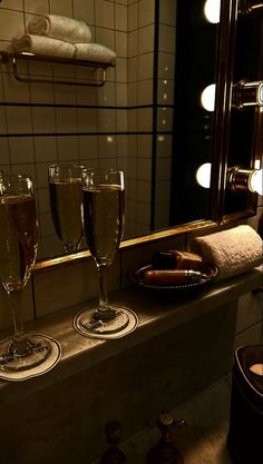 two glasses of champagne are sitting on a counter