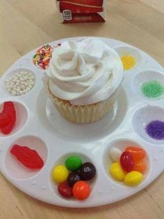 a cupcake with white frosting and candy on it