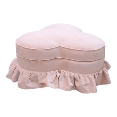 a pink round ottoman with ruffled edges and a white pillow on the top of it