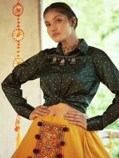 <ul>
<li style="text-align: justify;"><span data-preserver-spaces="true">Go for the sophisticated look with this classic mustard yellow color cotton fabric lehenga attached with Kutchi embroidered and mirror worked beautiful design with pom-pom tassels at the waist featured with layers at the bottom. </span></li>
<li style="text-align: justify;"><span data-preserver-spaces="true">Paired with green color gajji silk fabric long sleeve and shirt style Bohemian Art Silk Blouse For Puja, Semi-stitched Bandhani Print Bohemian Blouse, Bohemian Art Silk Blouse With Motifs, Bohemian Long Sleeve Sharara With Pallu, Bohemian Sharara With Unstitched Blouse For Festive Occasions, Festive Bohemian Sharara With Unstitched Blouse, Traditional Long Sleeve Wear With Cutdana For Navratri, Bohemian Sharara With Pallu For Navratri, Long Sleeve Traditional Wear With Cutdana For Navratri