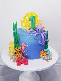 there is a blue cake with an octopus and sea animals on it, along with other decorations