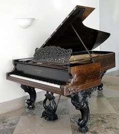 a grand piano sitting on top of a tiled floor