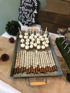 a tray filled with food on top of a table next to pine cones and candles