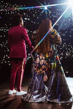 a man and woman standing on top of a dance floor in front of bright lights