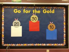 a bulletin board with the number 30 and two medals on it, in front of a classroom wall