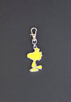 a yellow and white keychain with a cartoon character on it's side