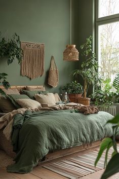 a bed with green sheets and pillows in a room filled with potted plants on the wall