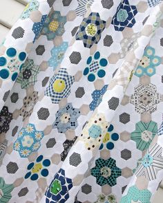 a close up view of a quilt made with hexagons and dots on it