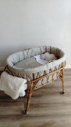 a wicker bassinet with white fur on the floor next to a wall