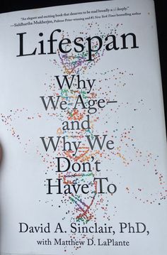 a person holding up a book about life span why age and why we don't have to