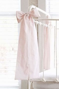 a baby crib with a pink bow hanging from it's side