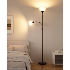 a lamp that is on top of a floor next to a bed and night stand