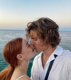 two people kissing each other while standing on a boat