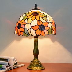 a lamp that is sitting on top of a table next to a book and some papers