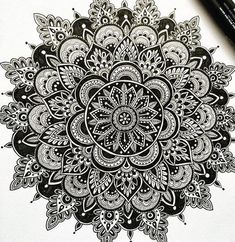 a black and white drawing of a flower with lots of doodles on the paper