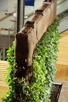 a bench that is made out of bricks and some plants on the ground next to it