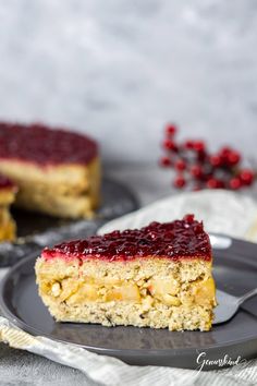 a piece of cake with cranberry sauce on it sitting on a black plate