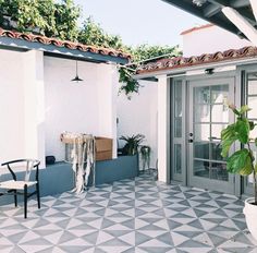 a patio with a chair, potted plant and door