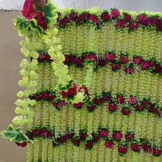 an arrangement of flowers is displayed on a wall in the shape of a vertical row