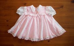 "Mod bubble gum pink retro baby dress - circa 1970's - is way too much fun   Lots of fabric makes it perfect for twirly. Lightweight pink under-layer is covered with a soft white poly lace-like top layer.  It has a real groovy look to it.  The bodice has some pink trimmed groovy lace. A pink bow on the bodice. Simple collar, gathered sleeves. 2 buttons on the back.  The tag reads: Size 12 months                            100% polyester The measurements of the dress as follows: - 7 1/2\" from shoulder seam to shoulder seam  - 12 1/2\" from the top of the button area at the back to the bottom of the dress In wonderful condition with no problems. A delightful little outfit to enjoy all over again" Pink Retro Dress With Peter Pan Collar, Retro Pink Ruffled Dresses, Pink Retro Dresses With Ruffles, Retro Pink Dresses With Ruffles, Pink Retro Dress With Ruffles, Retro Dress With Ruffles And Peter Pan Collar, Retro Dress With Peter Pan Collar And Ruffles, Retro Pink Dresses With Lace Trim, Pink Baby Dress