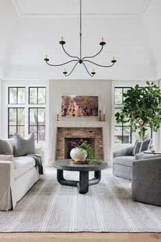 a living room filled with furniture and a fire place in front of a fireplace surrounded by windows