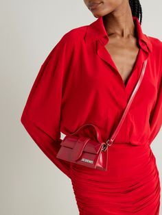 Jacquemus is  the  arbiter of micro bags - the smaller, the chicer. Nodding to Y2K with a hint of the '50s, this 'Le Bambino' tote is made from leather in a slim, rigid silhouette with a ladylike top handle. It'll hold a smartphone, keys and a cardholder. Luxury Red Bags, Bibi Bag Rouje, Luxury Red Smooth Grain Shoulder Bag, Jacquemus Le Bambino Tote Bag, Jacquemus Le Baneto Bag, Mini 24/24 Hermes, Sac Jacquemus Bambino, Mini Jacquemus, The Arbiter