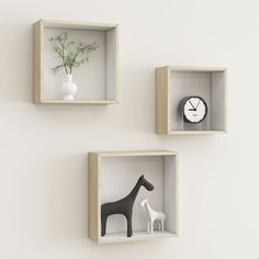 three wooden shelves with two different types of animals in them and a clock on the wall