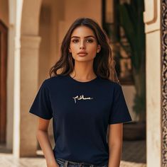 Our "Salam" T-Shirt combines elegance, comfort, and a minimalist touch. Crafted from 100% premium cotton, this navy blue t-shirt delivers a luxuriously soft feel, perfect for all-day wear. The design prominently features the word "Salam," which means "peace" in both Arabic and English. The text is superimposed in a sleek, contemporary style at the center of the chest, making it a subtle yet powerful symbol of tranquility. Designed with both durability and style in mind, this t-shirt includes shoulder-to-shoulder taping and double-needle stitching on the collar, sleeves, and hem, ensuring it maintains its shape and quality wash after wash. The relaxed, slightly oversized fit offers a modern, laid-back silhouette that complements any wardrobe. Key Features: Material: 100% ringspun cotton for English And Arabic, Calligraphy T, Navy Blue T Shirt, Arabic Words, Blue T Shirt, Fall Season, Shoulder Taping, Oversized Fits, Halloween Shopping