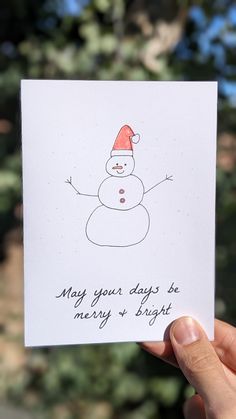 someone is holding up a card with a snowman on it that says, may your days be merry and bright