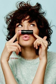 a woman holding a black object in front of her face