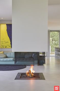 a living room filled with furniture and a fire place next to a wall mounted painting