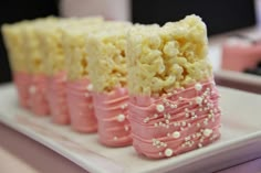 some kind of cake that is on a white plate with pink and yellow icing