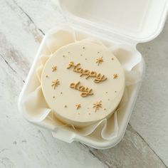 a cake in a plastic container with the words happy birthday written on it's side