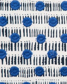 blue flowers on white fabric with black lines and dots in the background, closeup