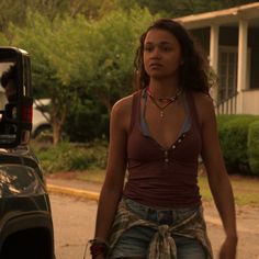 a woman standing next to a parked car