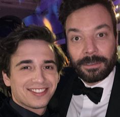 two men in tuxedos posing for a photo