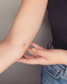 a woman's arm with a small tattoo on the left side of her arm