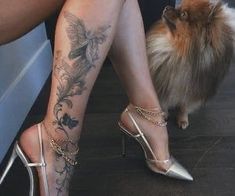 a woman's legs with tattoos on them and a small dog