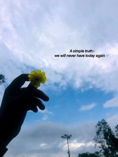 a person holding a yellow flower in front of a cloudy blue sky with a quote on it