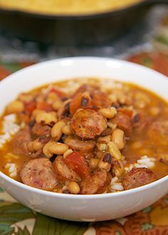 a white bowl filled with beans and sausage