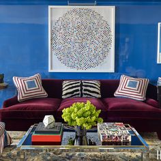 a living room with blue walls and purple couches in front of a coffee table