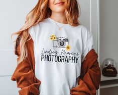 Our Photographer T-shirt - a perfect blend of personalization and timeless design. This unique shirt features a charming vintage camera and a vibrant sunflower, capturing the essence of photography and nature in one elegant print. Customize this shirt with your desired text, making it an ideal gift for a thoughtful friend, a fellow photography enthusiast, or a beloved family member. The fusion of the vintage camera and the sunflower adds an artistic touch, symbolizing creativity and radiance. Cr Photographer Tshirt, Photography Shirt, Shirt Photography, Photography Shirts, Business Shirt, Sunflower Shirt, Photographer Gifts, Photographer Shirts, Logo Gifts