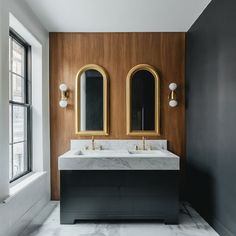 a bathroom with two sinks and mirrors on the wall next to each other in front of a window