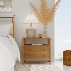 a bedroom with a bed, night stand and lamp on the nightstand next to it