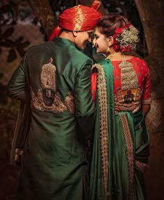 two people dressed in green and red standing next to each other