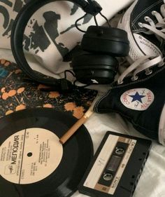 an old fashioned record, headphones, and other items on a bed