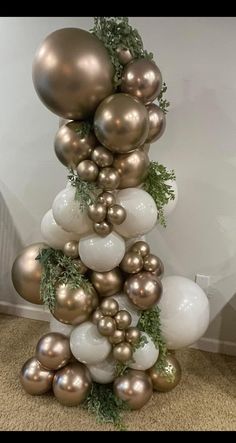 a christmas tree made out of balloons and greenery on the bottom half of it