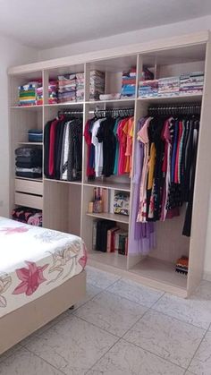 a bedroom with a bed and closets full of clothes on it's shelves