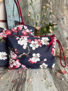 two floral bags sitting on top of a wooden table