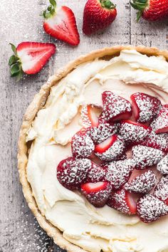 a pie with powdered sugar and strawberries on top